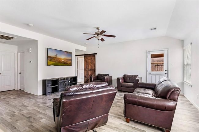 The living room, showing doors to the backyard and the primary suite. | Image 15