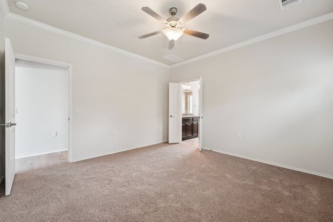 Unfurnished room with light carpet, crown molding, a ceiling fan, a smoke detector, and baseboards | Image 20