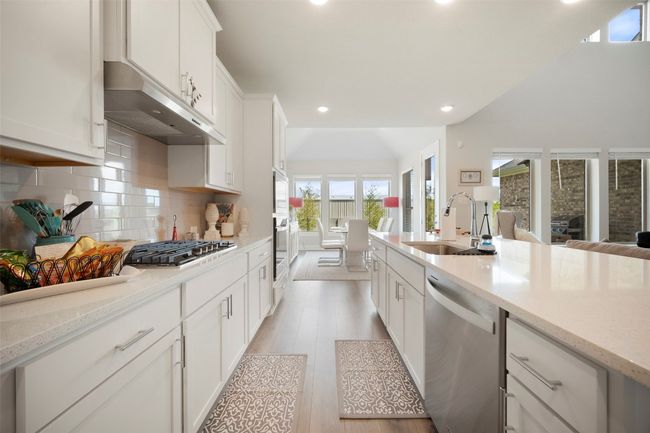 Kitchen with appliances with stainless steel finishes, under cabinet range hood, recessed lighting, white cabinets, and light wood-type flooring | Image 20