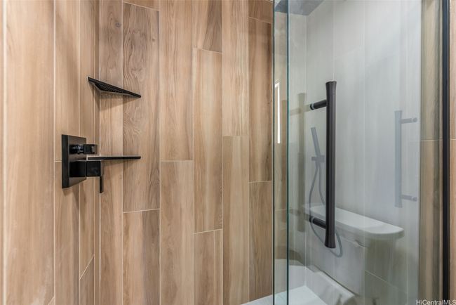 Closer look at glass-enclosed shower with tile tub surround... | Image 15