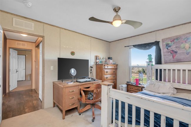 Bedroom with visible vents and ceiling fan | Image 29