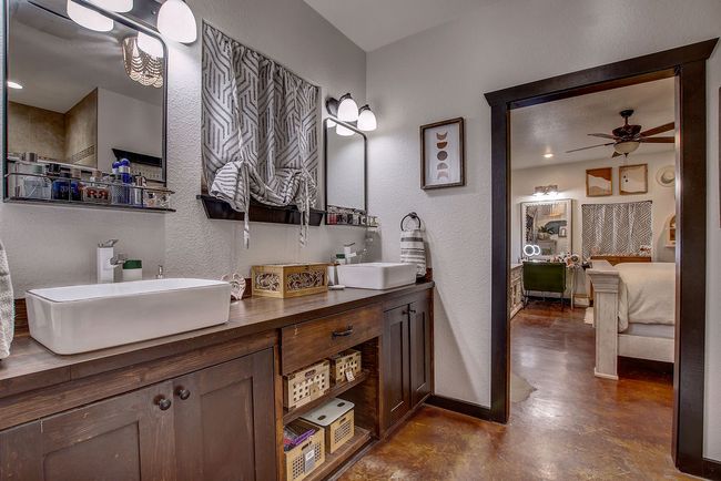 Full bath featuring connected bathroom, concrete floors, a sink, and baseboards | Image 16
