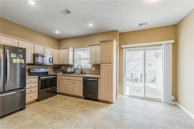 Kitchen featuring a sink, appliances with stainless steel finishes, light brown cabinets, and light countertops | Image 6