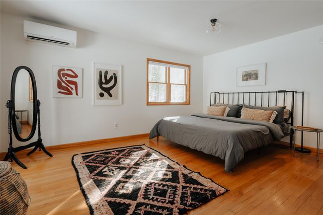 Bedroom featuring a wall mounted air conditioner and hardwood / wood-style flooring | Image 12