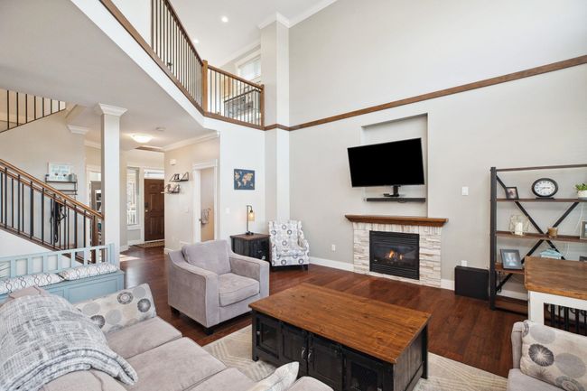Living room featuring ornamental molding, baseboards, stairway, and wood finished floors | Image 5