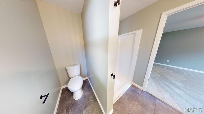 Bathroom with toilet, baseboards, and tile patterned flooring | Image 16