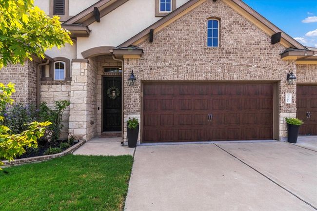 French country inspired facade featuring driveway, an attached garage, and stucco siding | Image 4