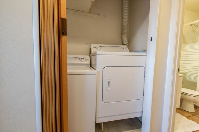Clothes washing area featuring washing machine and dryer and laundry area | Image 15