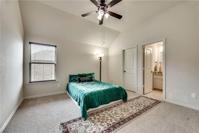 Bedroom with light carpet, vaulted ceiling, baseboards, and ensuite bathroom | Image 19