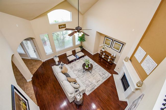 From above, the living room reveals its full scale—towering windows, fireplace, and visual access to the kitchen below—emphasizing the openness and architectural detailing that define the home. | Image 21