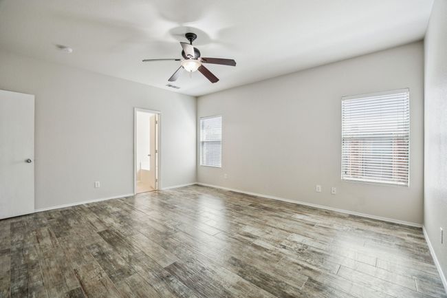Spare room with a ceiling fan, wood finished floors, and a smoke detector | Image 15
