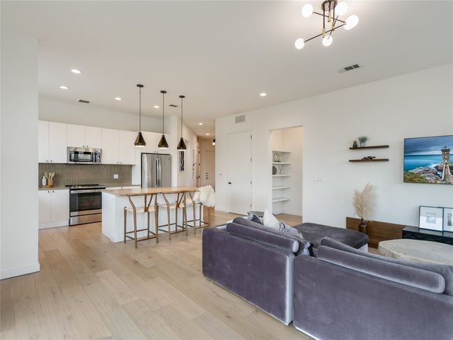 Living room featuring visible vents, light wood-style flooring, and a chandelier | Image 7