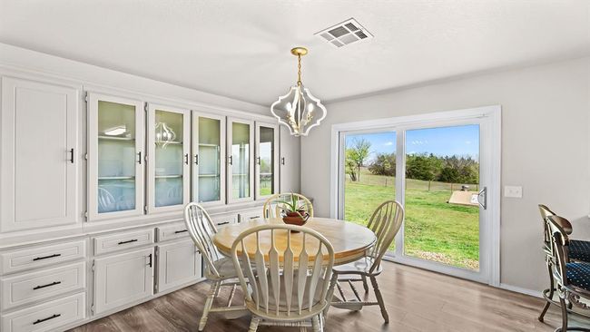 Dining room featuring a chandelier, light wood-type flooring, and visible vents | Image 36