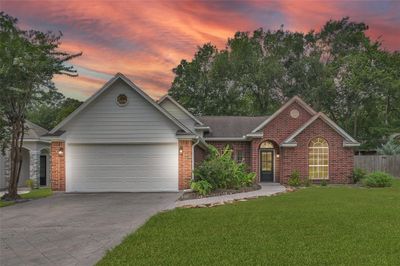 This photo captures the impressive curb appeal of this immaculate property, showcasing its beautifully manicured lawn and mature trees. | Image 2