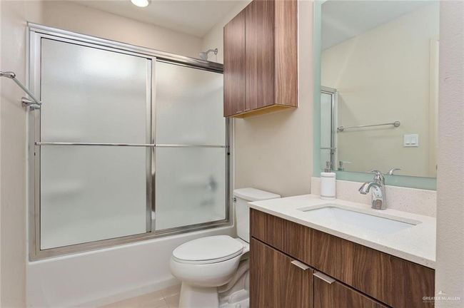 Bathroom featuring vanity, enclosed tub / shower combo, and tile patterned flooring | Image 14