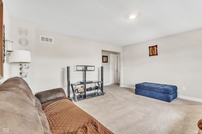 living area featuring carpet flooring, baseboards, and visible vents | Image 17