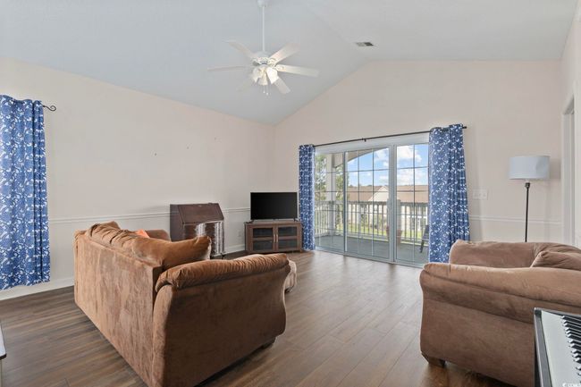 Living area featuring ceiling fan, dark wood-style flooring, and high vaulted ceiling | Image 9