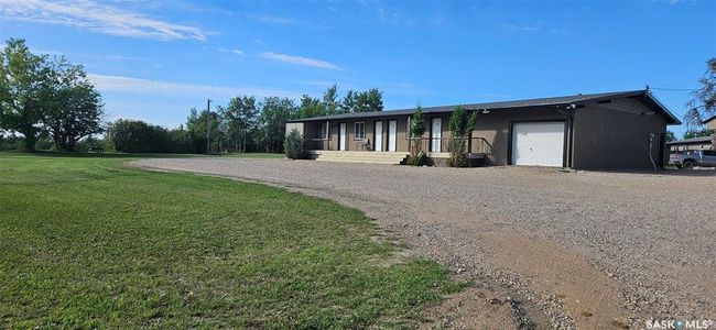 View of front facade with a garage, gravel driveway, and a front yard | Image 9