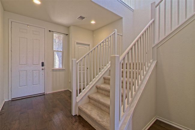 Entryway featuring dark wood-style floors, stairway, and recessed lighting | Image 5
