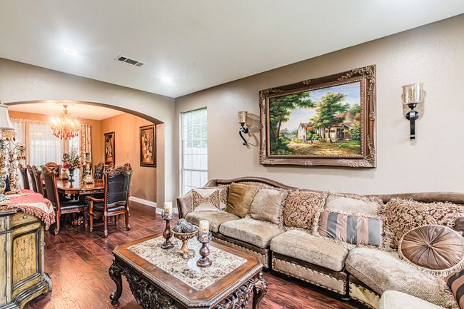 Living room featuring arched walkways, a chandelier, dark wood-style flooring, and recessed lighting | Image 8