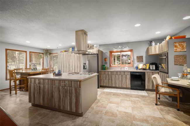 Kitchen featuring appliances with stainless steel finishes, modern cabinets, island exhaust hood, recessed lighting, and a center island | Image 28