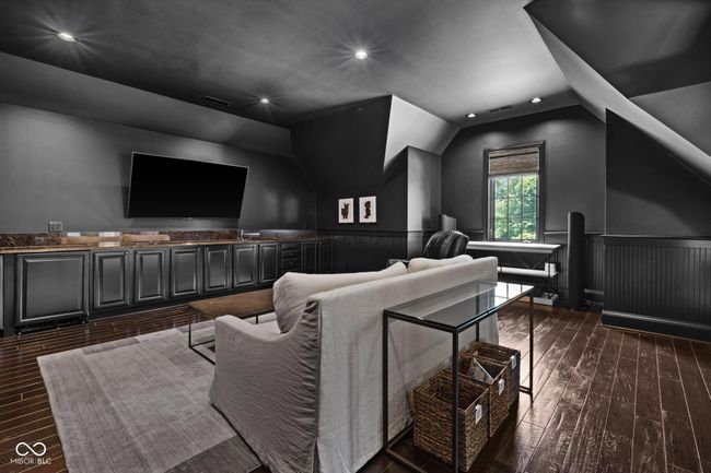 home theater featuring vaulted ceiling, dark wood-style floors, wainscoting, and recessed lighting | Image 68