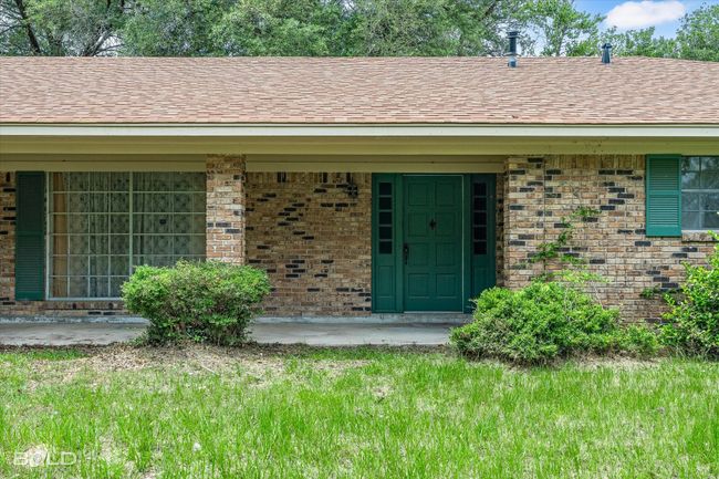 View of exterior entry with brick siding and roof with shingles | Image 27