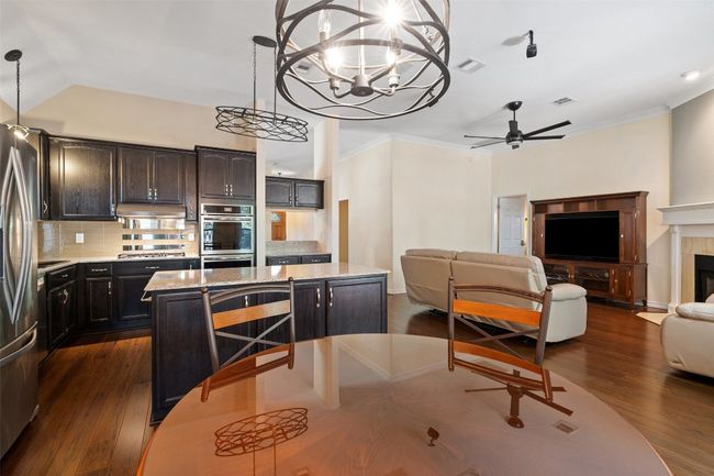 Kitchen with stainless steel appliances, open floor plan, a kitchen island, backsplash, and a ceiling fan | Image 20