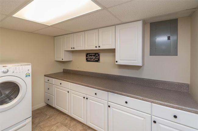 Washroom featuring electric panel, cabinet space, and washer / dryer | Image 22
