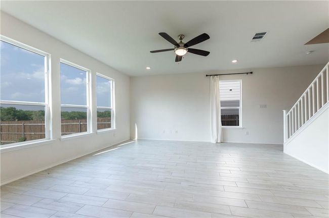 Unfurnished room with ceiling fan, recessed lighting, and stairs | Image 9