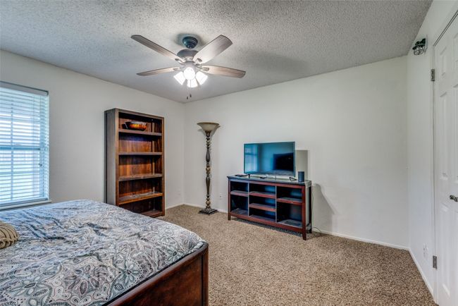 Bedroom with carpet floors, a textured ceiling, baseboards, a ceiling fan, and a closet | Image 10