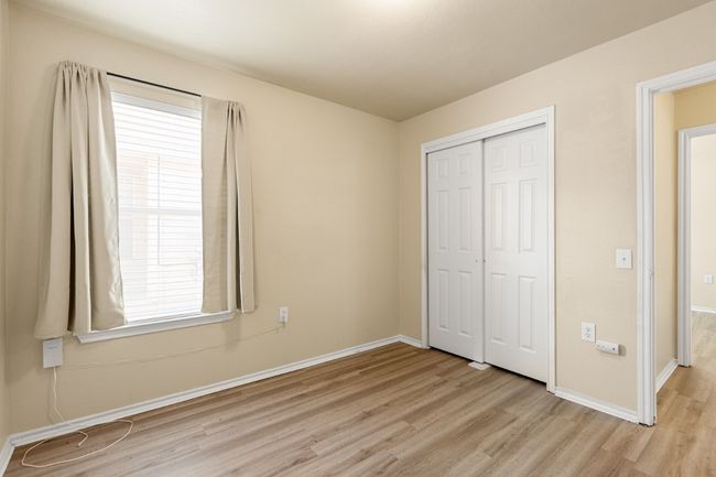 Unfurnished bedroom with light wood-type flooring, a closet, and multiple windows | Image 21