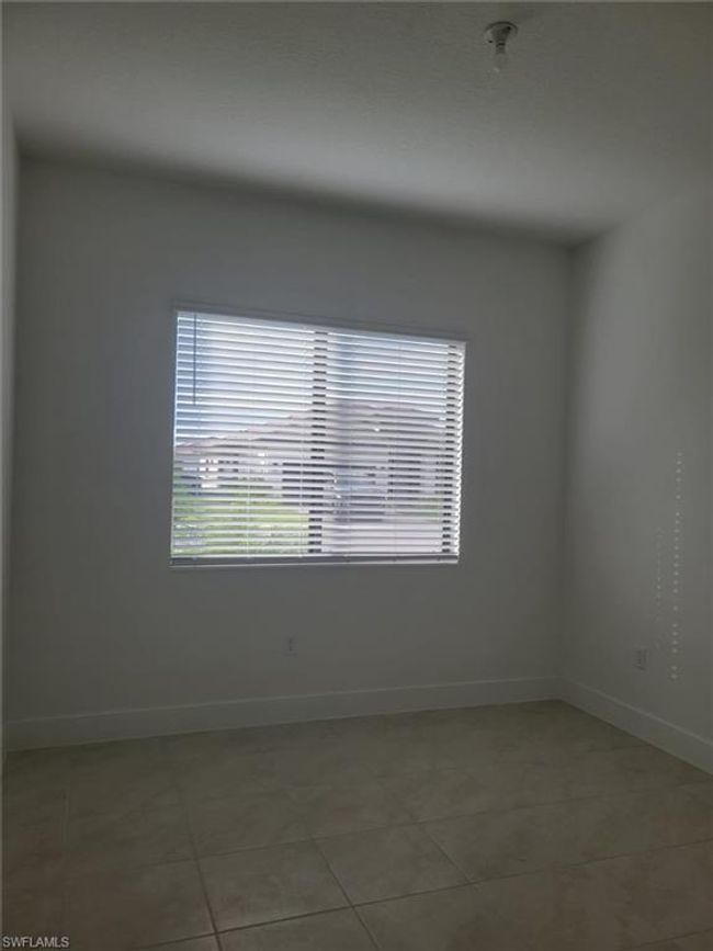 Spare room featuring light tile patterned floors and baseboards | Image 16