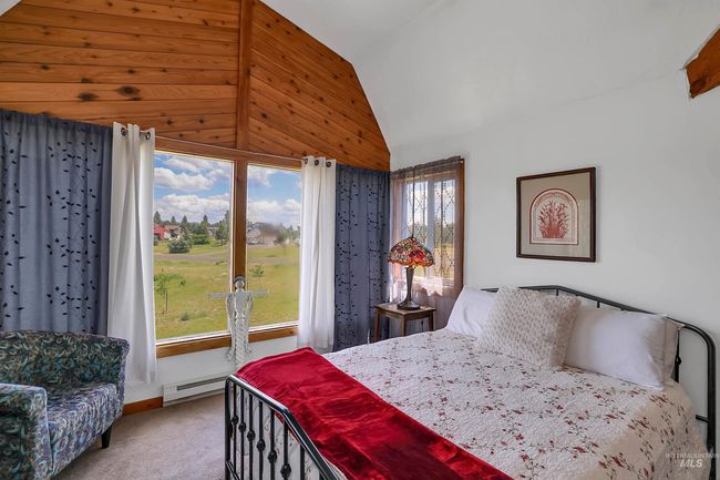 Carpeted bedroom featuring a baseboard heating unit and high vaulted ceiling | Image 27
