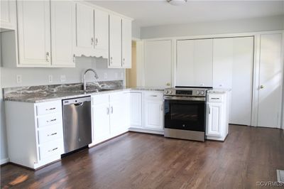 Kitchen featuring dark hardwood / wood-style floors, white cabinets, appliances with stainless steel finishes, and sink | Image 3