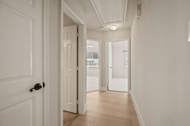 Hallway with light wood-style floors, baseboards, and attic access | Image 26
