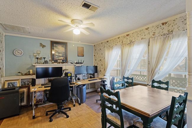 Dining room with fireplace is currently set up as home office. | Image 12