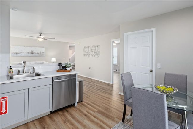 Kitchen featuring ceiling fan, dishwasher, light countertops, light wood-style flooring, and a sink | Image 14