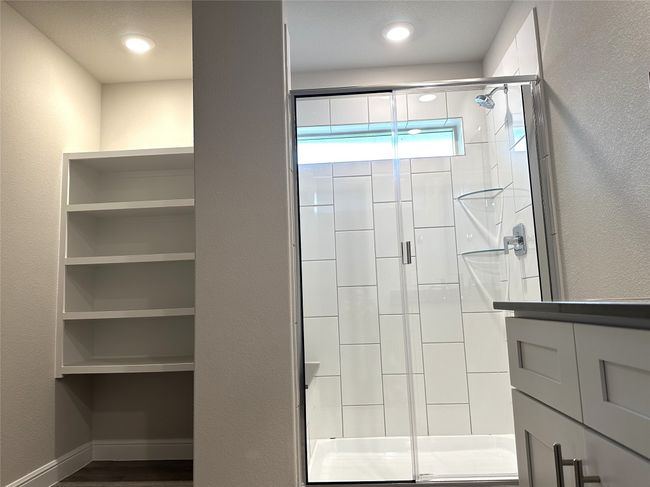 Bathroom featuring a shower stall and wood finished floors | Image 10