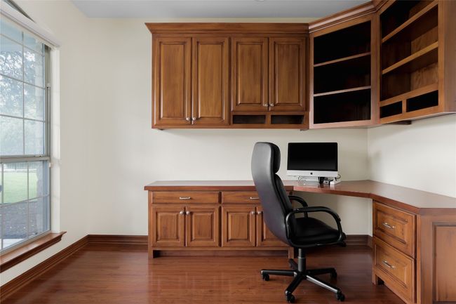 Home office with built in study area, baseboards, and dark wood-style floors | Image 25