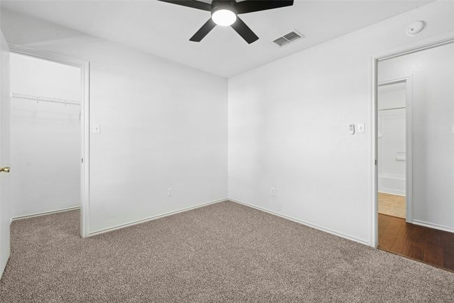 Unfurnished bedroom featuring a spacious closet, carpet floors, a closet, and a ceiling fan | Image 21