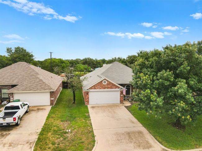 View of front of property featuring brick siding, a garage, a front yard, and concrete driveway | Image 31