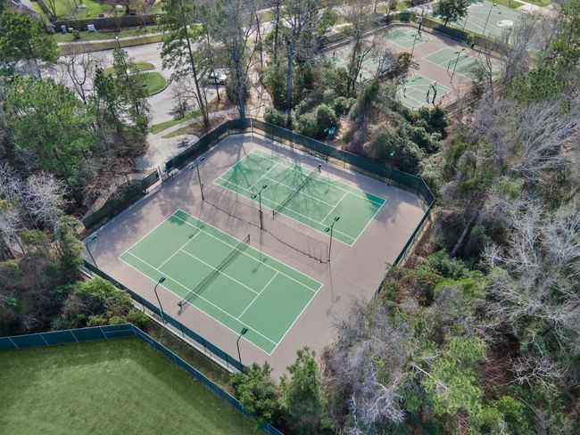 Explore the beautifully maintained tennis courts nestled within the amenity-rich Spring Trails community. Surrounded by lush greenery, these courts provide an ideal setting for sports enthusiasts seeking recreation and leisure. | Image 43