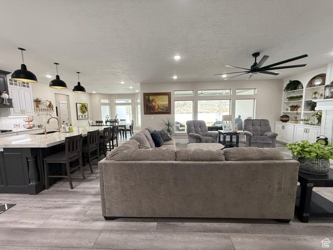 Living area with a textured ceiling, ceiling fan, light wood-style flooring, and recessed lighting | Image 11