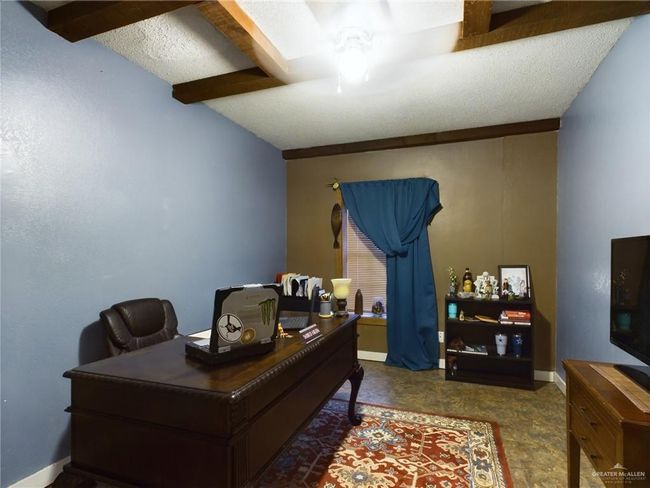 Carpeted office with a textured ceiling, ceiling fan, and beamed ceiling | Image 17