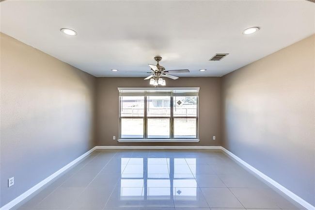 Tiled empty room with a ceiling fan and recessed lighting | Image 4