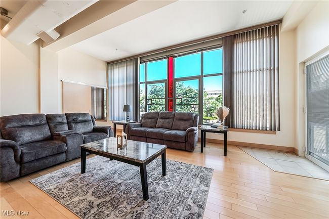 Great room with light wood finished floors and balcony access. | Image 9