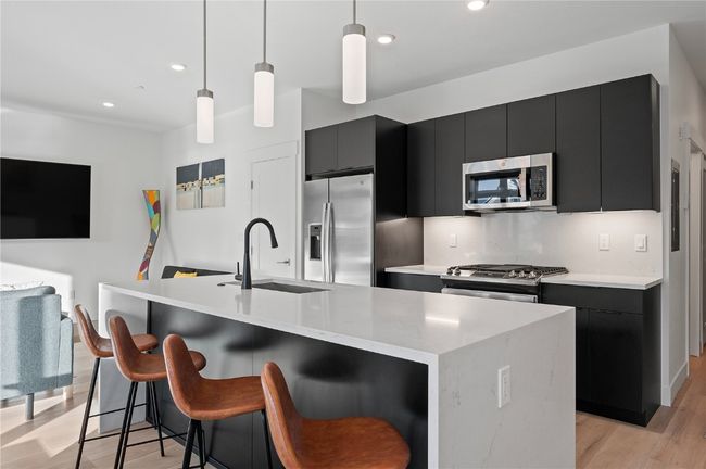 Kitchen featuring pendant lighting, a center island with sink, and stainless steel appliances | Image 5
