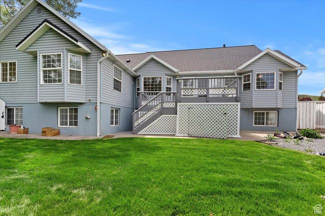 Back of house with stucco siding, a lawn, stairs, and a patio | Image 27
