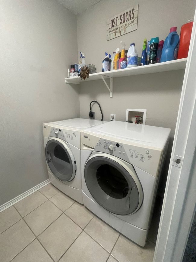 Laundry area with washer and clothes dryer and light tile patterned floors | Image 15